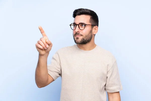 Jovem Homem Bonito Com Barba Sobre Fundo Azul Isolado Tocando — Fotografia de Stock