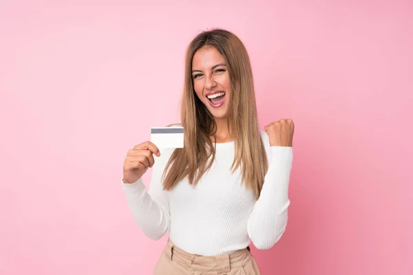 Młoda Blondynka Odizolowanym Różowym Tle Kartą Kredytową — Zdjęcie stockowe