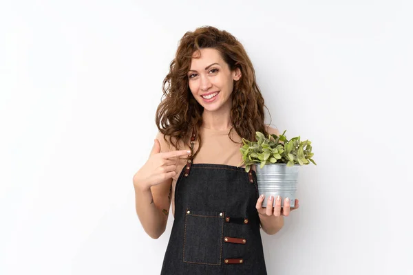 Jovem Mulher Bonita Sobre Fundo Isolado Tomando Vaso Flores Apontando — Fotografia de Stock