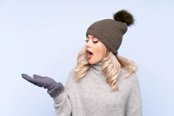 Giovane Adolescente Con Cappello Invernale Sfondo Blu Isolato Tenendo Copyspace — Foto Stock