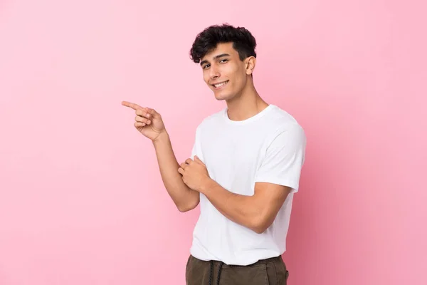 Молодой Аргентинский Мужчина Изолированном Розовом Фоне Указывая Пальцем Сторону — стоковое фото