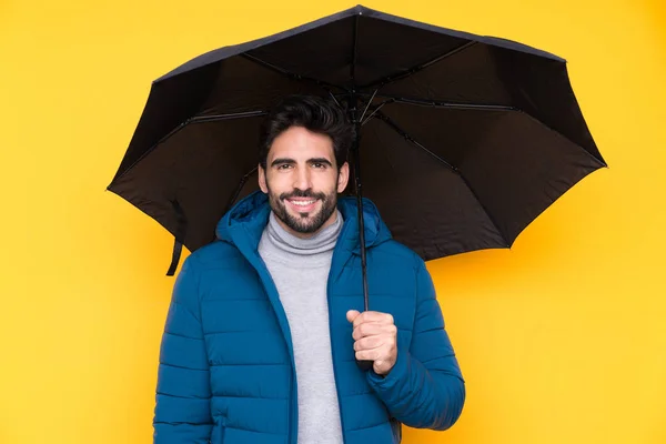 男を保持傘上隔離された黄色の背景多くの笑顔 — ストック写真