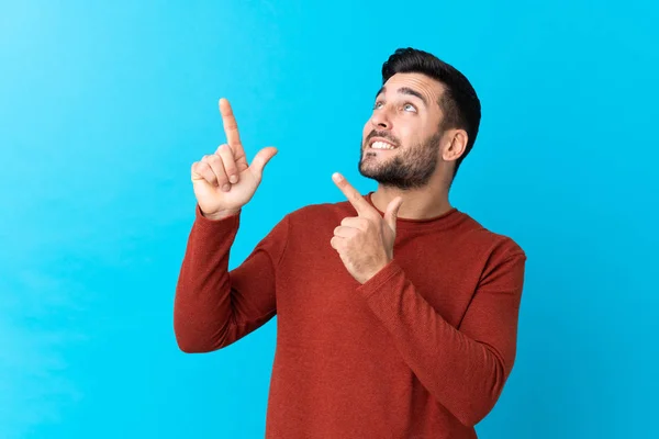 Jonge Knappe Man Met Baard Geïsoleerde Blauwe Achtergrond Wijzend Met — Stockfoto