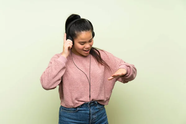 Jonge Tiener Aziatische Meisje Geïsoleerde Groene Achtergrond Luisteren Naar Muziek — Stockfoto