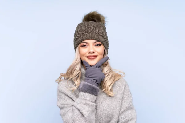 Kışlık Şapkalı Genç Kız Mavi Arka Planda Gülüyor — Stok fotoğraf