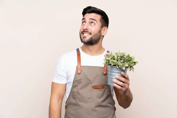 Jardinero Hombre Sosteniendo Una Planta Sobre Fondo Aislado Riendo Mirando —  Fotos de Stock