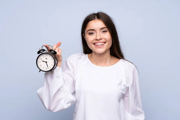 Jonge Vrouw Geïsoleerde Blauwe Achtergrond Met Vintage Wekker — Stockfoto