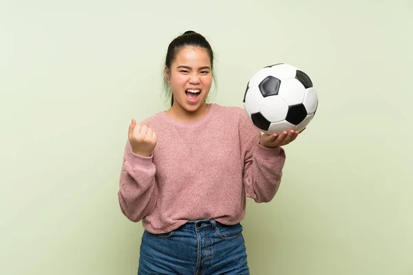 Jonge Tiener Aziatische Meisje Geïsoleerde Groene Achtergrond Houden Een Voetbal — Stockfoto