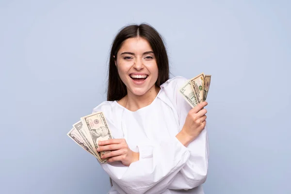 Joven Mujer Sobre Aislado Azul Fondo Tomando Montón Dinero —  Fotos de Stock