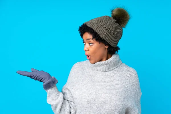 African American Woman Winter Hat Isolated Blue Background Holding Copyspace — Stock Photo, Image