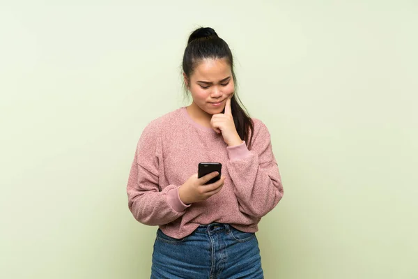 Junge Teenager Asiatische Mädchen Über Isolierte Grüne Hintergrund Mit Mobiltelefon — Stockfoto