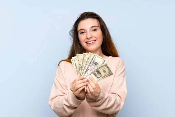 Joven Morena Chica Sobre Aislado Azul Fondo Tomando Montón Dinero — Foto de Stock