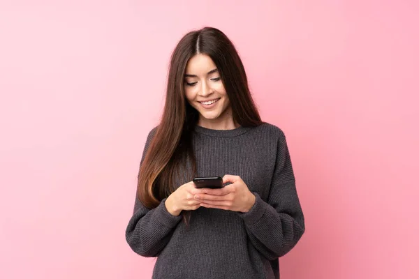 Giovane Donna Sfondo Rosa Isolato Invio Messaggio Con Cellulare — Foto Stock