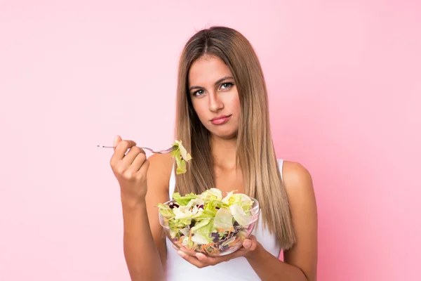 Young blonde woman with salad over isolated background — Stock Photo, Image