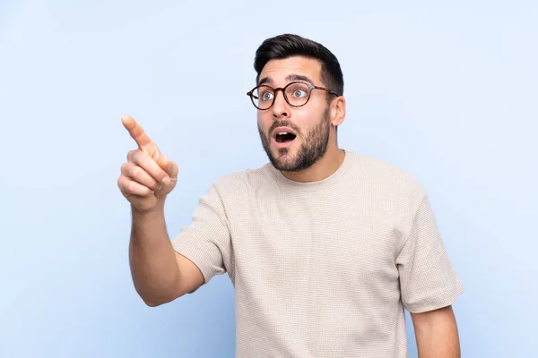 Joven Hombre Guapo Con Barba Sobre Fondo Azul Aislado Apuntando — Foto de Stock