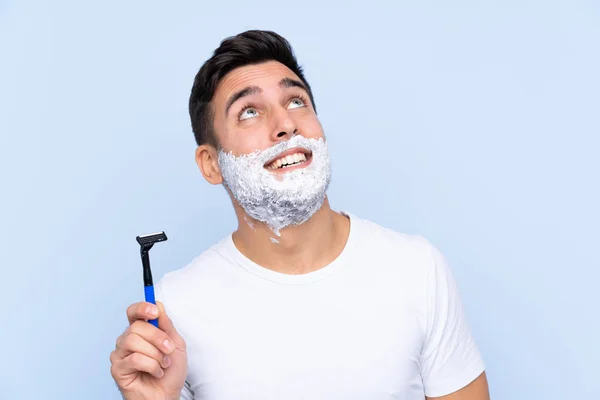Jovem Bonito Homem Barbear Sua Barba Sobre Isolado Fundo Olhando — Fotografia de Stock