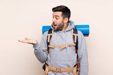 Arka planı izole edilmiş büyük bir sırt çantasıyla genç dağcı.