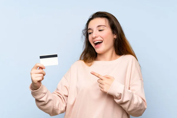 Jovem Morena Sobre Fundo Azul Isolado Segurando Cartão Crédito — Fotografia de Stock