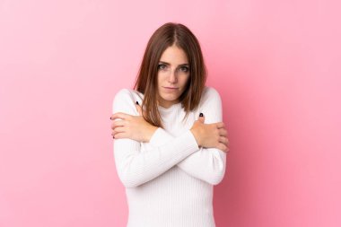 Soyutlanmış pembe arka plan donmuş genç bir kadın.