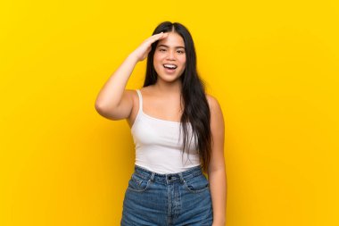 Genç Asyalı kız sarı arka planda bir şeyin farkına vardı ve çözüme niyetlendi.