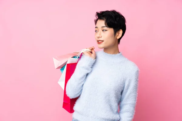 Young Asian Girl Isolated Pink Background Holding Shopping Bags Looking — ストック写真