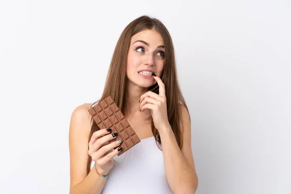 Young Woman Isolated White Background Taking Chocolate Tablet Having Doubts — Stock Photo, Image