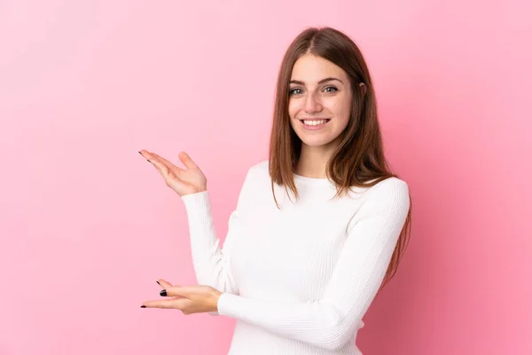 Ung Kvinna Över Isolerad Rosa Bakgrund Sträcker Händerna Sidan För — Stockfoto