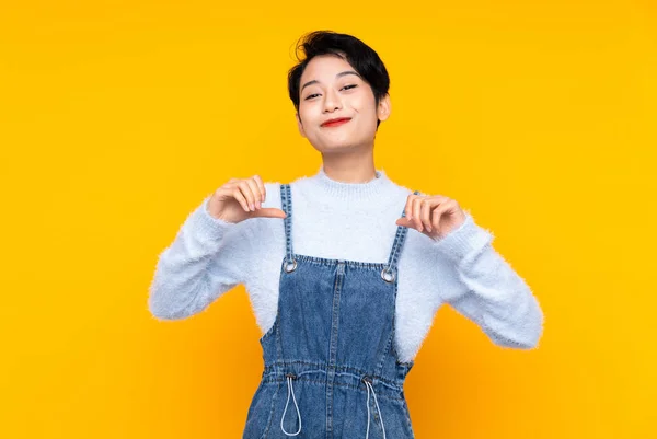 Junge Asiatische Mädchen Overalls Über Isolierten Gelben Hintergrund Stolz Und — Stockfoto