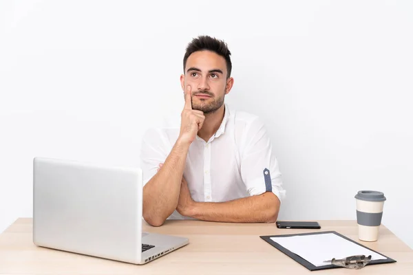 Joven Hombre Negocios Con Teléfono Móvil Lugar Trabajo Pensando Una — Foto de Stock