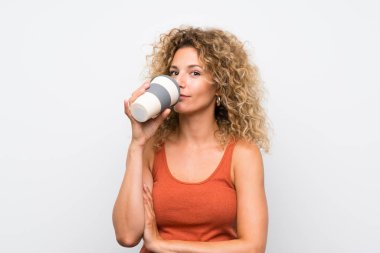 Kıvırcık saçlı genç sarışın kadın kahve götürmek tutarak