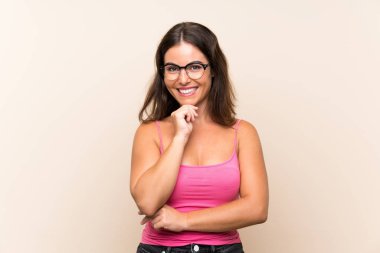 Gözlüklü ve gülümseyen, izole beyaz arka planı olan genç bir kadın.