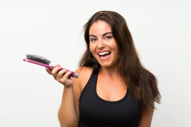 Saç tarak ile izole beyaz arka plan üzerinde genç kadın