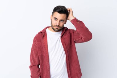 Sakallı, kadife ceket giyen genç ve yakışıklı bir adam soyutlanmış beyaz bir arka plan ve hayal kırıklığı ifadesi var.