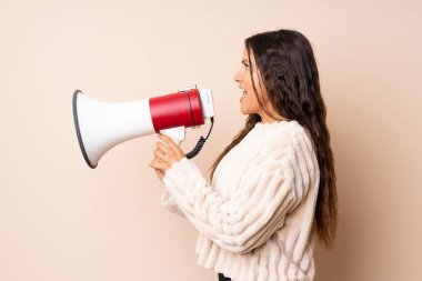 Soyutlanmış arka planda genç bir kadın megafonla bağırıyor.