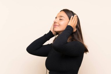 Genç esmer kız izole duvar üzerinde müzik dinliyor