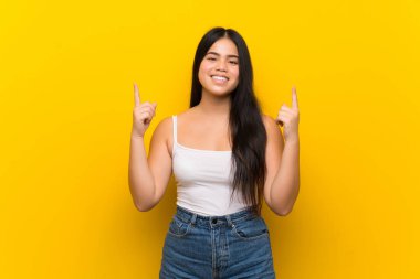 Genç Asyalı kız izole edilmiş sarı arka plan harika bir fikre işaret ediyor.