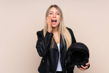 Motosiklet kasklı genç sarışın kadın izole edilmiş arka planda ağzı açık bağırıyor.