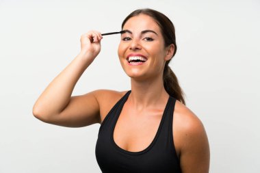 Kozmetik acele ile maskara uygulayarak izole beyaz arka plan üzerinde genç kadın