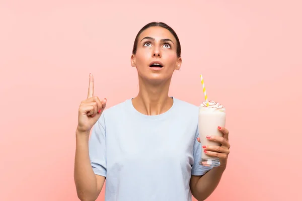 Mujer Joven Con Batido Fresa Sobre Fondo Rosa Aislado Señalando —  Fotos de Stock