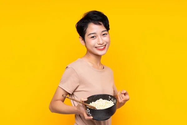 Giovane Ragazza Asiatica Sfondo Giallo Isolato Che Indica Mentre Tiene — Foto Stock