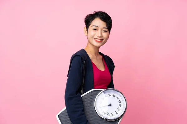 年轻的亚洲女子体育运动员 背对孤立的粉色背景 配重机 — 图库照片