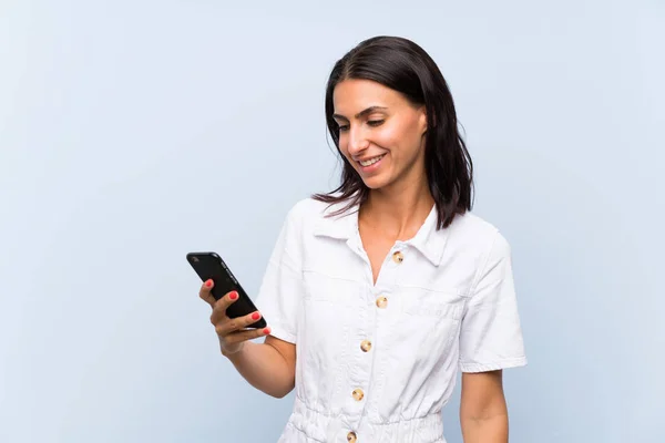 Junge Frau Mit Handy Über Einsamer Blauer Wand Lächelt Viel — Stockfoto