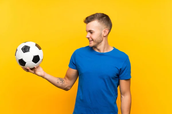Νέος Όμορφος Ξανθός Άνθρωπος Κρατώντας Μια Μπάλα Ποδοσφαίρου Πάνω Από — Φωτογραφία Αρχείου