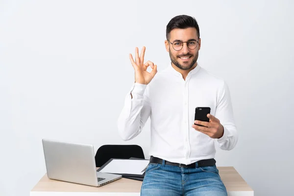 Joven Hombre Negocios Sosteniendo Teléfono Móvil Mostrando Signo Con Los — Foto de Stock