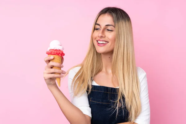 Jonge Uruguayaanse vrouw met een cornet ijs over geïsoleerd roze — Stockfoto