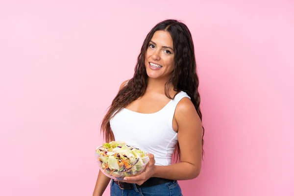 Jeune femme avec salade sur mur isolé — Photo