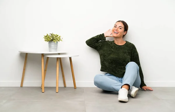 Mujer Joven Sentada Suelo Escuchando Algo — Foto de Stock