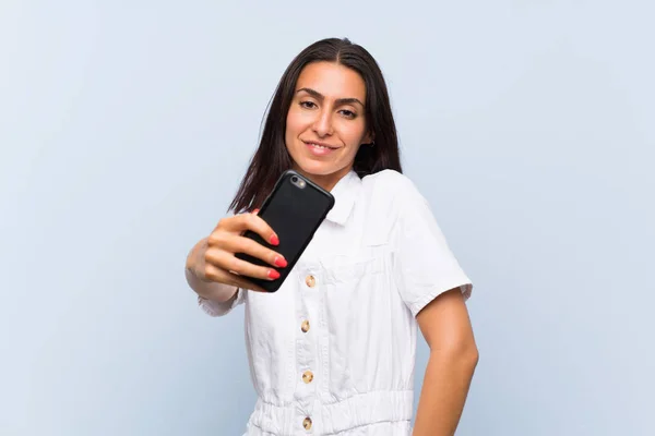 Giovane donna con un telefono cellulare fare un selfie — Foto Stock