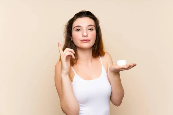 Young brunette girl with moisturizer over isolated background Stock Picture