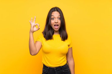 Genç esmer kız izole edilmiş geçmişinde şaşırmış ve iyi işaretler gösteriyor.